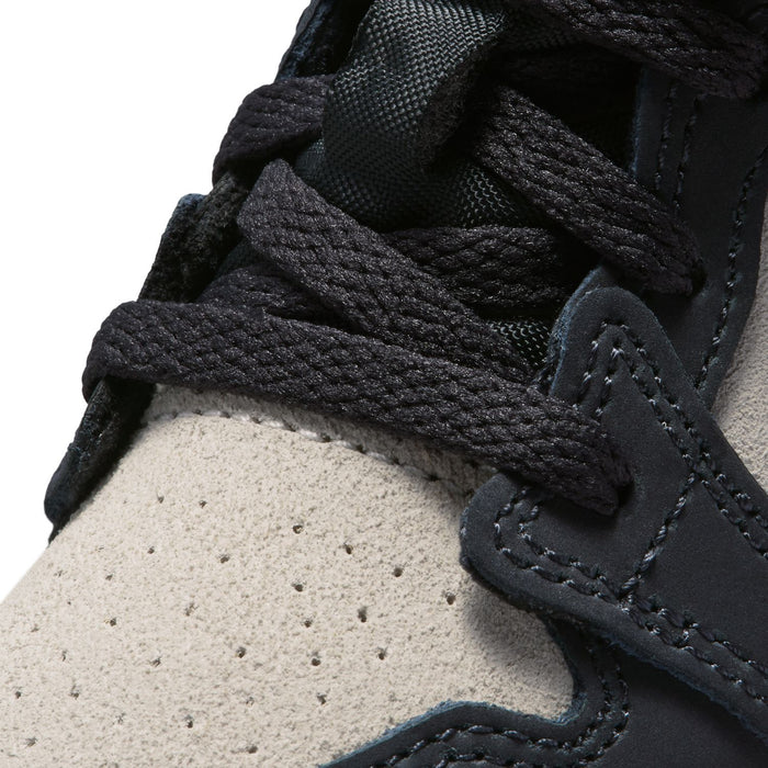 Close-up of toddler mid-top sneaker lace and stitching on off-white and black panels