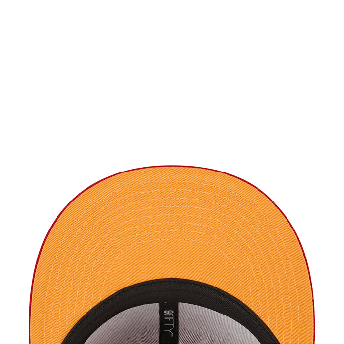 Orange snapback baseball cap close-up with black inner brim and gray size label