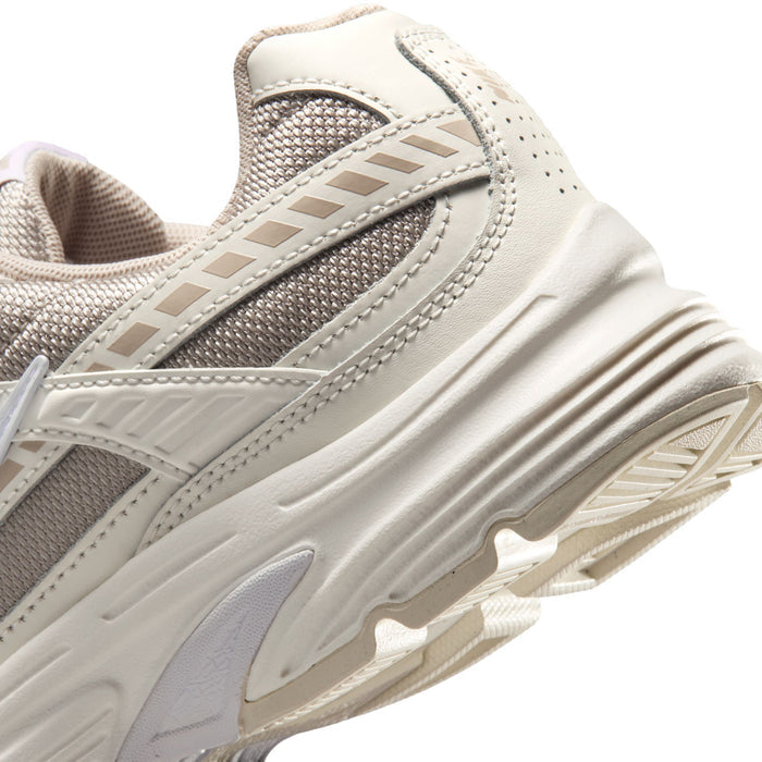 Women's sneaker side close-up showing textured midsole and stripe detail in cream and tan
