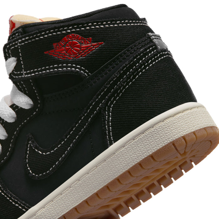 Kids black high-top sneaker close-up with red emblem on the side and textured midsole