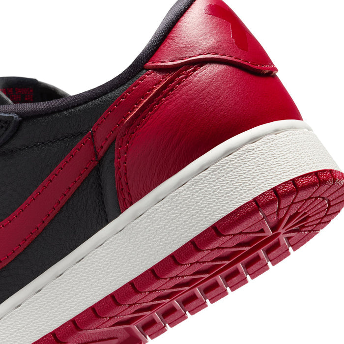 Youth sneaker side detail, black leather with red overlay and white midsole edge