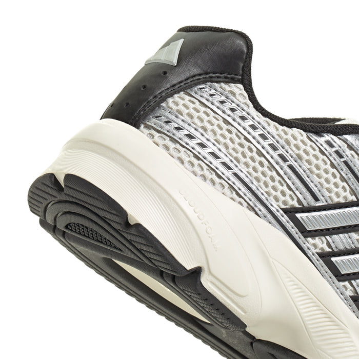 Women’s shoe side close-up with silver upper, black collar, and thick white midsole