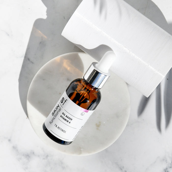 Skincare serum bottle with dropper on a marble surface