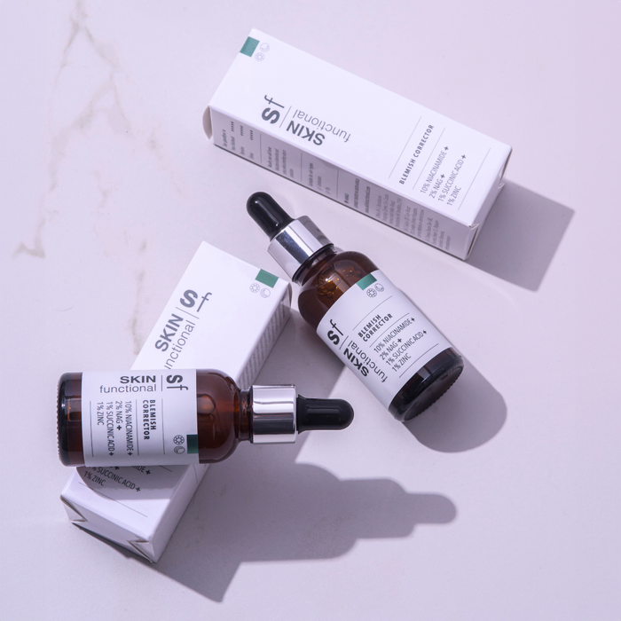 Hand holding a Skin Functional Blemish Corrector Bottle
