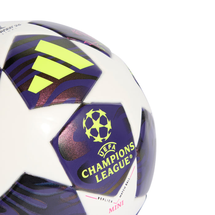 Mini soccer ball close-up featuring Champions League badge, neon yellow Adidas icon, purple panels