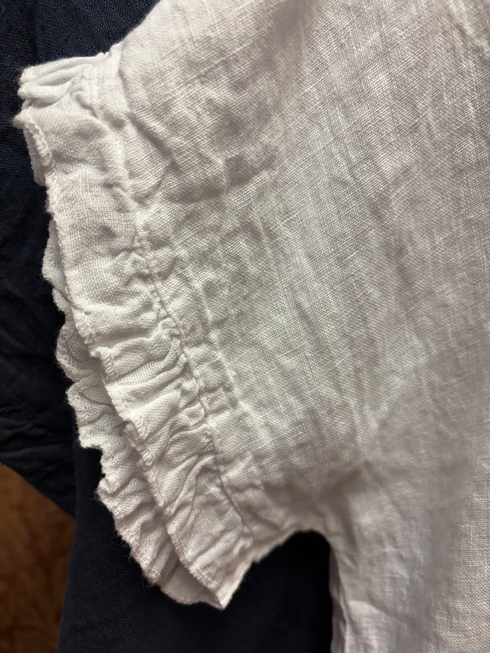 Camille & Co. ruffle linen top featuring a flowy design with ruffled sleeves and a lightweight, breezy fabric for warm weather.