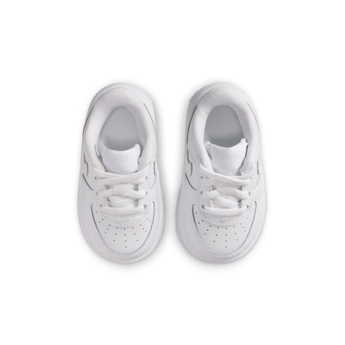 Pair of toddler white low-top sneakers, top view with laces and perforations