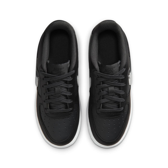 Youth low-top sneakers viewed from above; black uppers with black laces and white edge