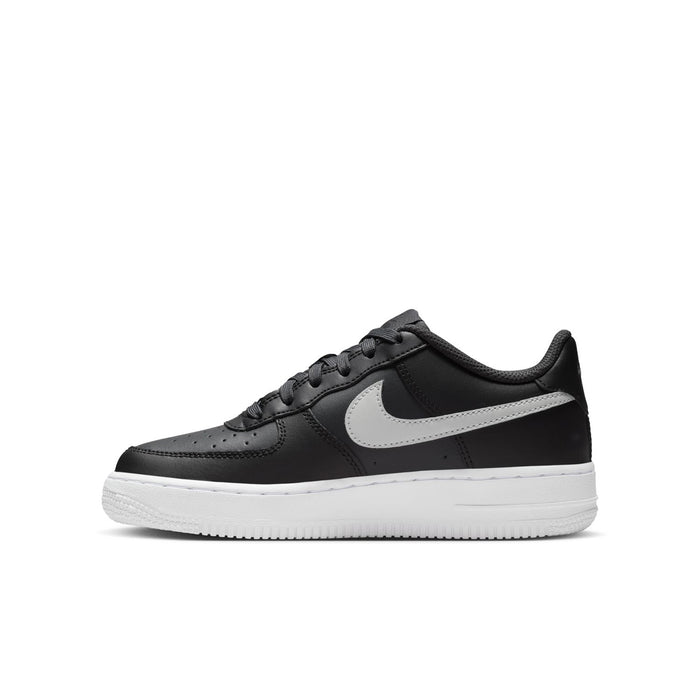 Youth low-top sneaker side view with dark leather, silver swoosh, and white sole