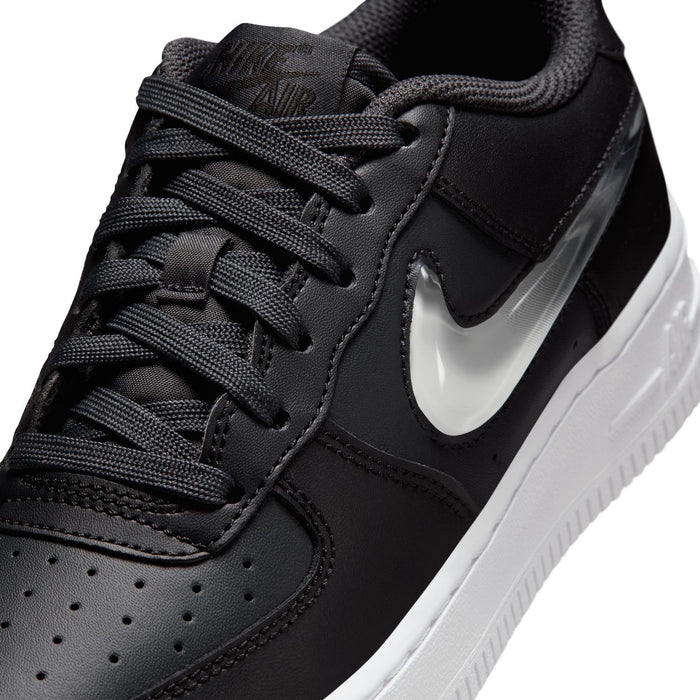 Close-up of youth low-top sneaker laces and dark leather upper with silver swoosh