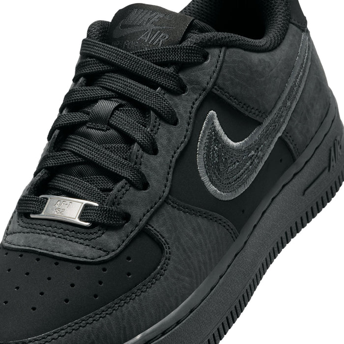 Air Force 1 LV8 youth sneakers close-up, dark charcoal laces and swoosh