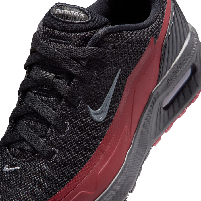 Youth sneaker close-up: black mesh laces, red side panel, and silver swoosh