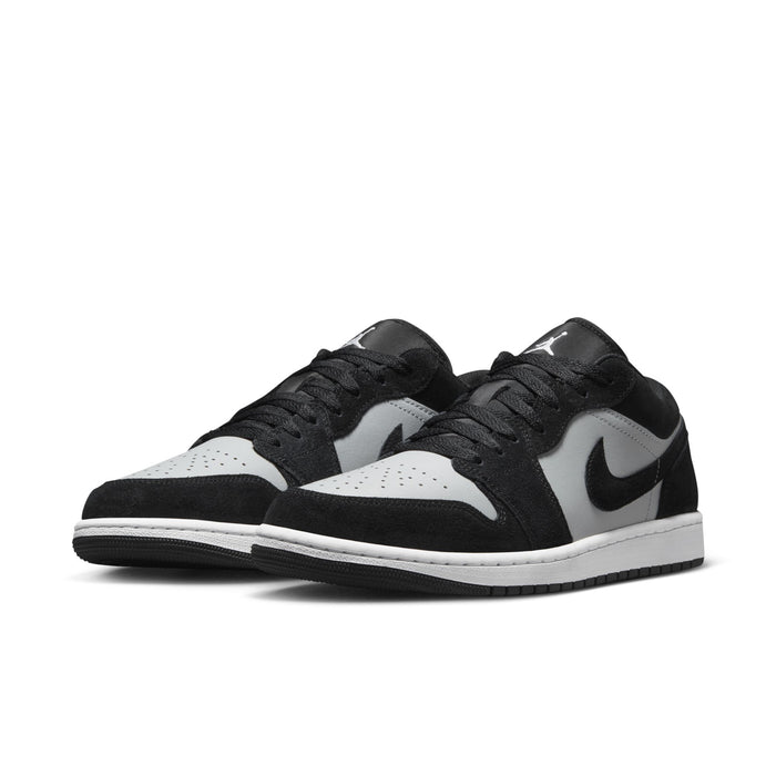 Black, white, and gray low-top sneakers with two-tone swoosh and black laces