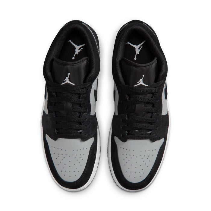 Pair of black and white low-top sneakers with perforated toe and lace-up