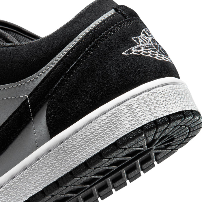Black suede sneaker side close-up with stitched swoosh and textured outsole