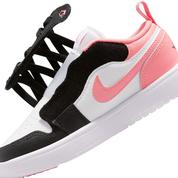 Kids' low-top sneakers close-up: black and white panels with pink swoosh detail