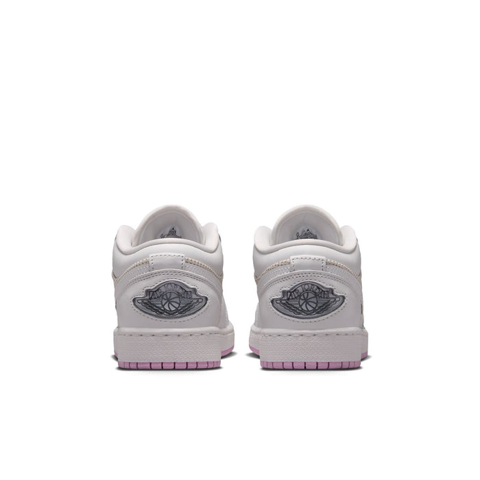 Youth low-top sneakers heel view in white with dark logo patch and pink-striped outsole