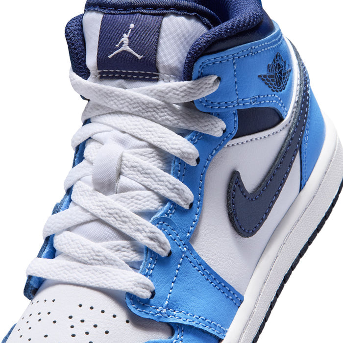 Kids sneaker close-up showing white laces, blue-and-navy collar, and swoosh