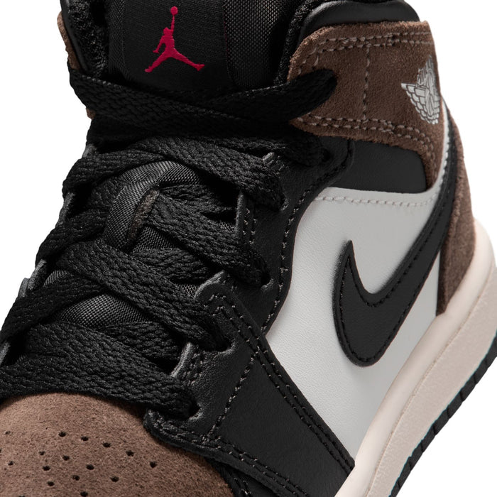 Kids mid-top sneaker close-up with black laces, brown suede, and red Jumpman