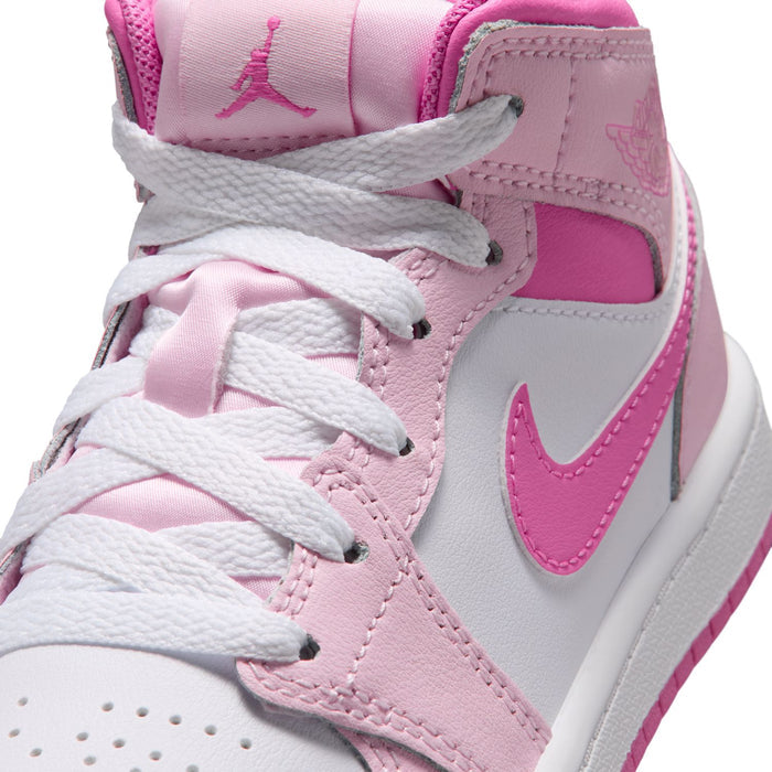 Kids' mid-top sneakers close-up, pink leather panels and white lace