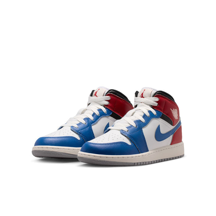 Youth Air Jordan 1 Mid sneakers pair in white, blue, and red with black accents.