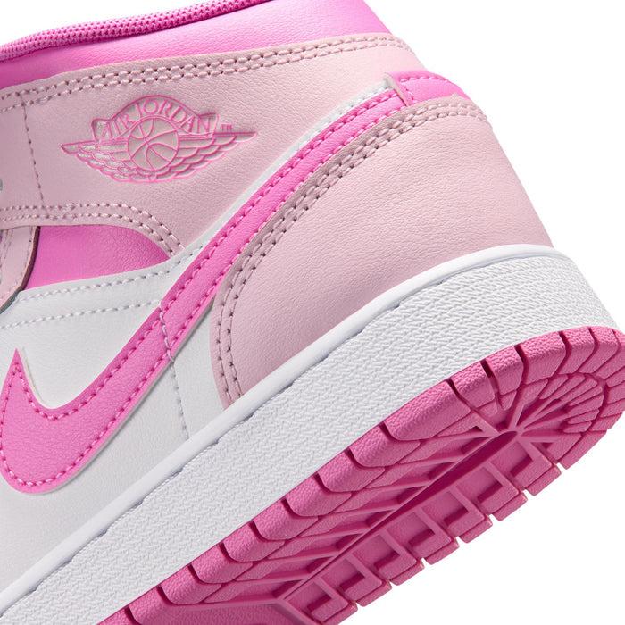 Close-up of youth sneakers showing pink outsole tread and side Swoosh detail