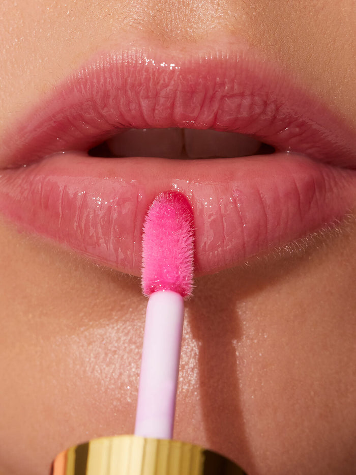 luscious -- barely there tinted lip oil close up applying to models lips