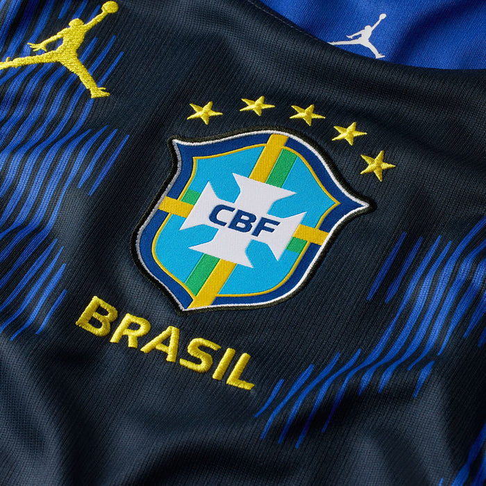 Brazil away soccer jersey close-up showing CBF crest, BRASIL text, and gold stars