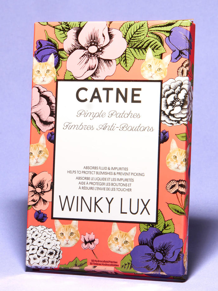 close up of cat shaped pimple patches in box on purple background