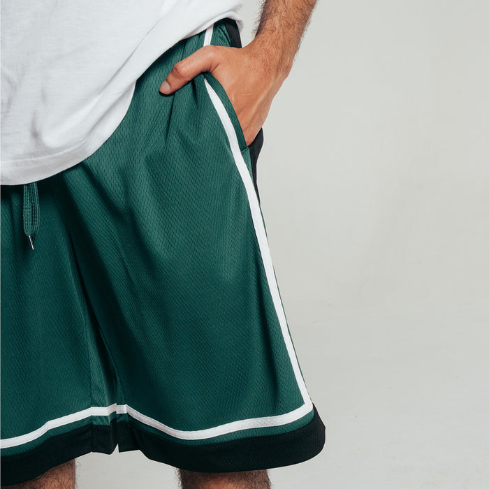 Men's green basketball shorts close-up with black hem and white side stripe detailing