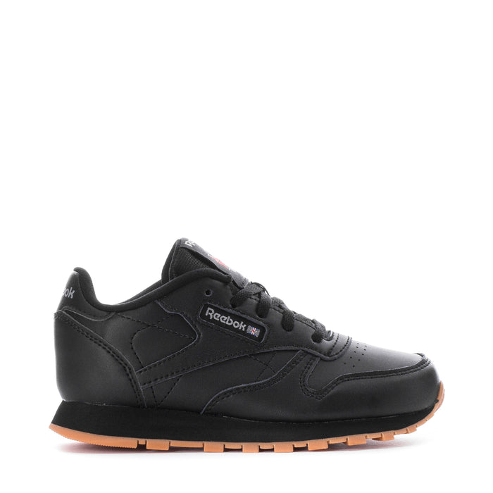 Kids black leather sneaker with Reebok logo and gum rubber sole, front 3/4 view.