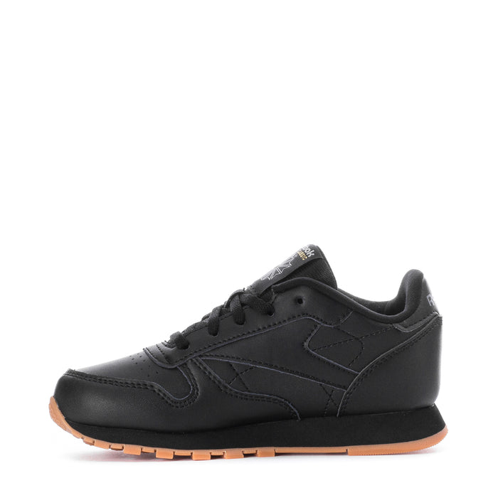 Kids black leather sneaker, side profile with laces and gum rubber outsole.