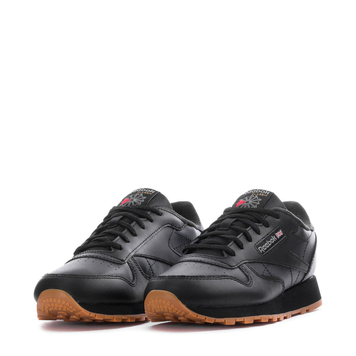 Pair of youth black leather sneakers with lace-up design and gum outsole