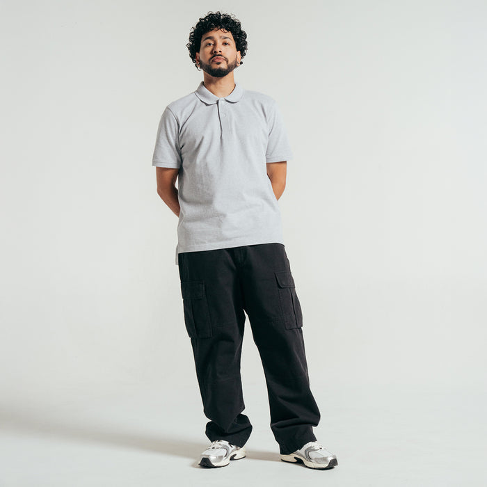 Men's heather grey pique polo shirt on model, standing with collar and buttons