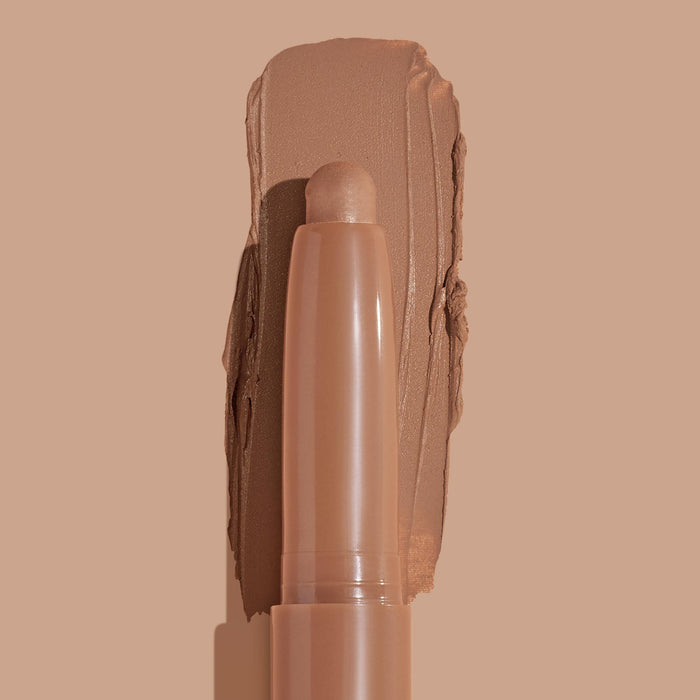 ColourPop Shadow Stix in Cocktail Party showcasing the creamy stick tip against a wide swipe of warm matte tan pigment, highlighting smooth payoff and portable eyeshadow stick on a matching nude background.