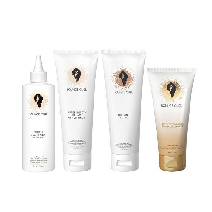 Four Bounce Curl hair care products arranged together including Gentle Clarifying Shampoo, Super Smooth Cream Conditioner, Defining Butter, and Moisture Balance Leave-In Conditioner