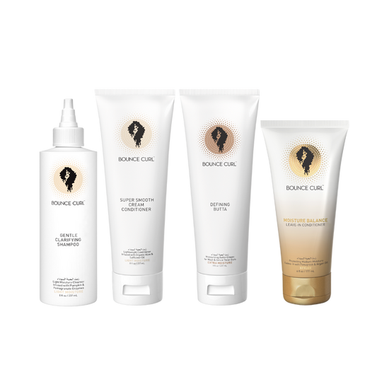 Four Bounce Curl hair care products arranged together including Gentle Clarifying Shampoo, Super Smooth Cream Conditioner, Defining Butter, and Moisture Balance Leave-In Conditioner