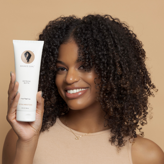 Woman showcasing her defined, bouncy curls that were achieved using this Bounce Curl product.