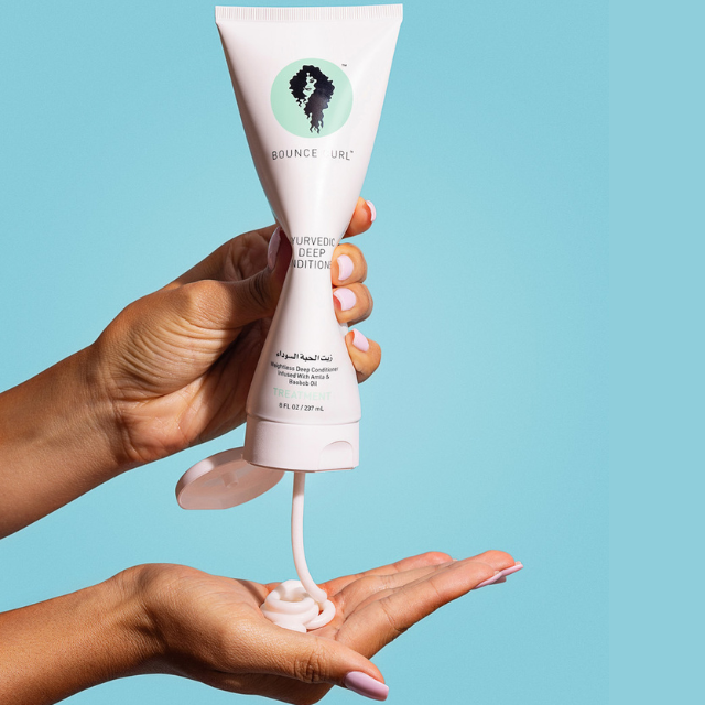 Bounce Curl product is being put on a woman's hand for application.