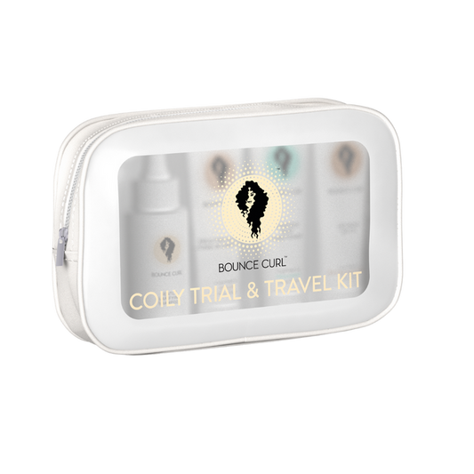 A clear zip pouch labeled Bounce Curl Coily Trial & Travel Kit containing several small product bottles