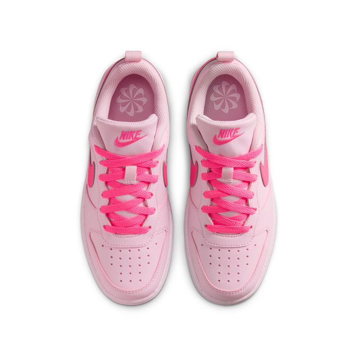 Youth pink low-top sneakers with lace-up front, patterned lining, and swoosh details