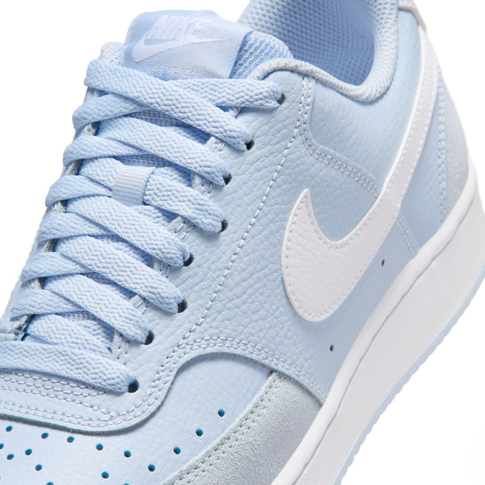 Close-up of light blue lace-up sneakers with textured leather and white Swoosh.