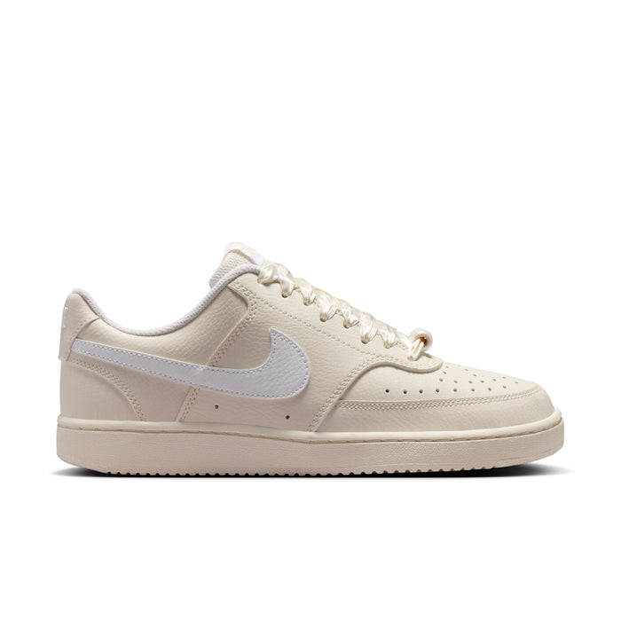 Women’s low-top cream Nike sneakers, lace-up style with light blue Swoosh
