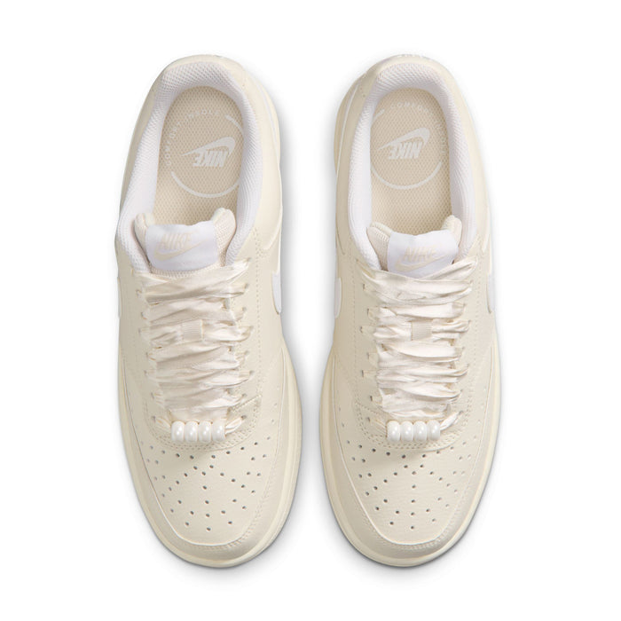Top view of women’s cream Nike low-top sneakers with white laces and perforated toe