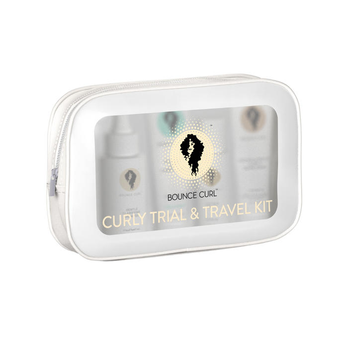 A clear zip pouch labeled Bounce Curl Curly Trial & Travel Kit containing several small product bottles