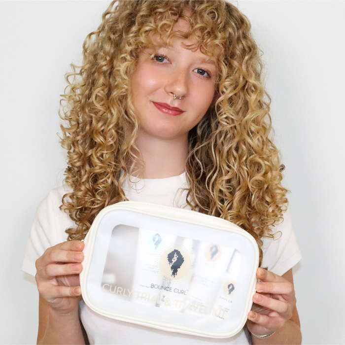 Model with defined curls using Bounce Curl curly trial kit, featuring top curly hair products.