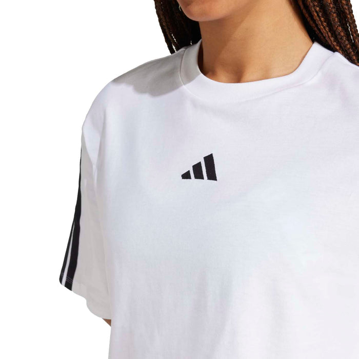 Close-up of white women's loose t-shirt with adidas logo and black sleeve stripes