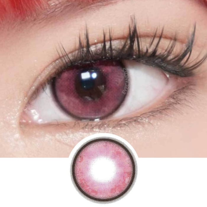 A close-up of an eye with long lashes wearing EyeCandys Powerglow Reddish Pink color contact lens. Below, a separate image shows a single pink UV protection lens from EyeCandys.