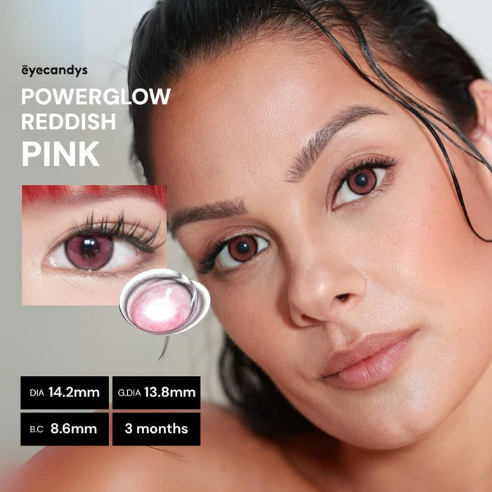 A woman with smooth skin wears vibrant EyeCandys Powerglow Reddish Pink color contacts. Close-up reveals: DIA 14.2mm, G.DIA 13.8mm, B.C 8.6mm, UV protection, lasts 3 months. Text: "EyeCandys Powerglow Reddish Pink".