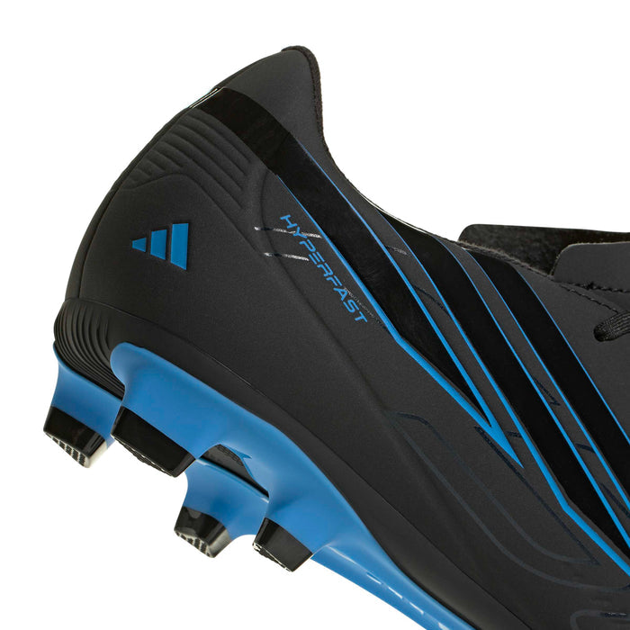 Side close-up of black and blue cleat showing studs and Speedstripe design